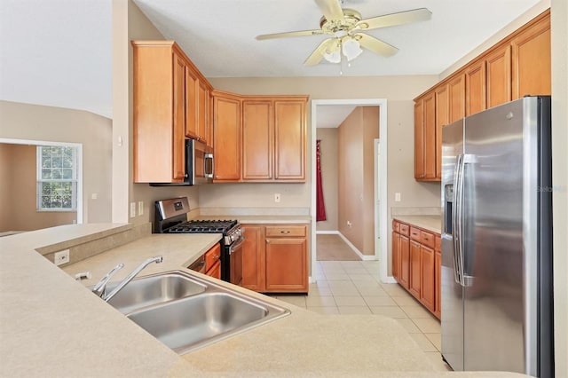 kitchen with sink, kitchen peninsula, appliances with stainless steel finishes, light tile patterned floors, and ceiling fan