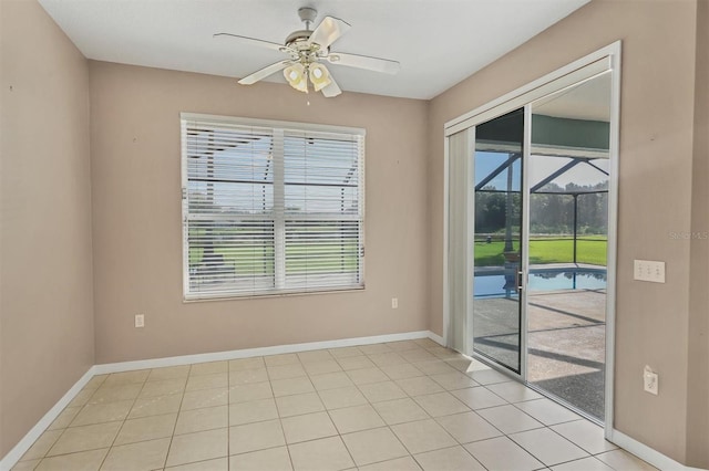 tiled empty room featuring ceiling fan and a wealth of natural light