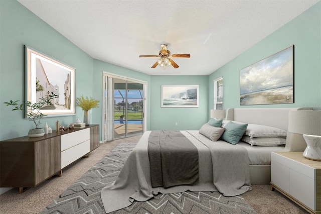 carpeted bedroom featuring ceiling fan, a textured ceiling, and access to exterior