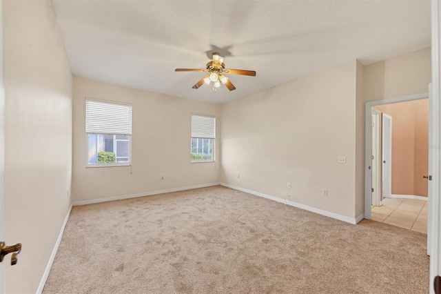 carpeted spare room with ceiling fan