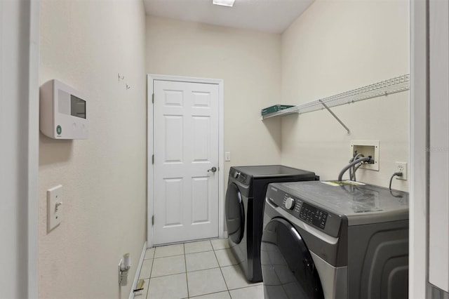 laundry room featuring washer and clothes dryer and light tile patterned flooring