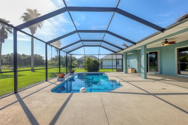 view of swimming pool featuring a lawn, ceiling fan, a lanai, and a patio area