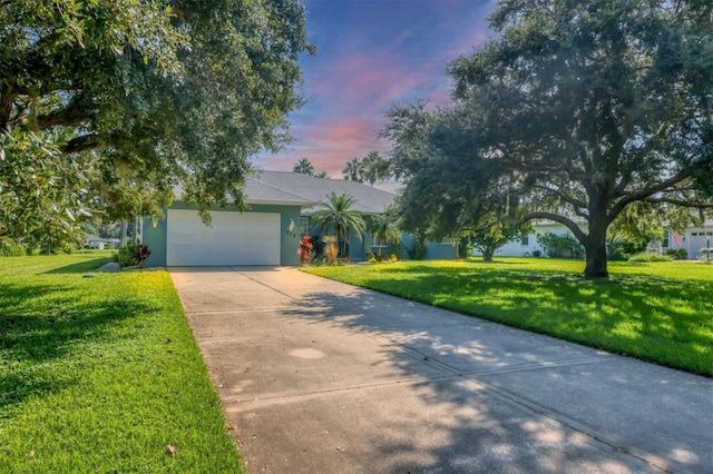 view of front of property featuring a garage and a lawn