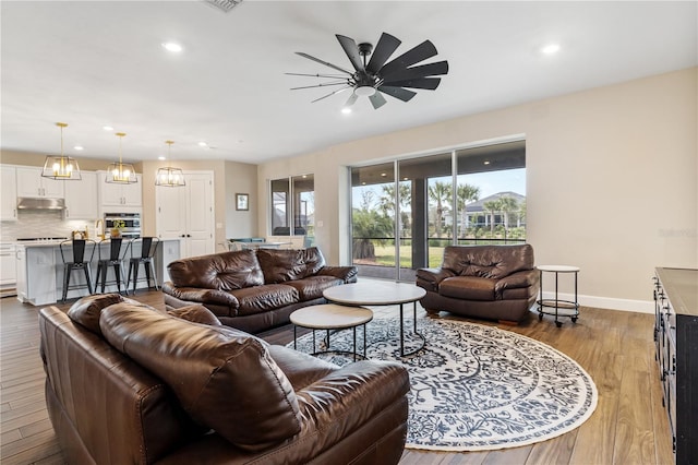 living room featuring ceiling fan and hardwood / wood-style flooring