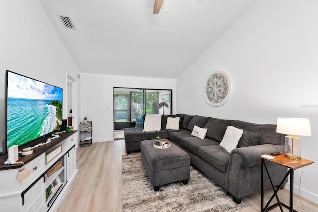 living room with ceiling fan, lofted ceiling, and light hardwood / wood-style floors