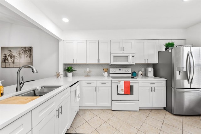 kitchen with backsplash, white appliances, sink, and white cabinets