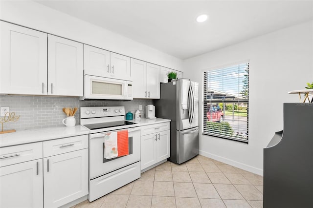 kitchen with light tile patterned floors, white cabinets, tasteful backsplash, and white appliances