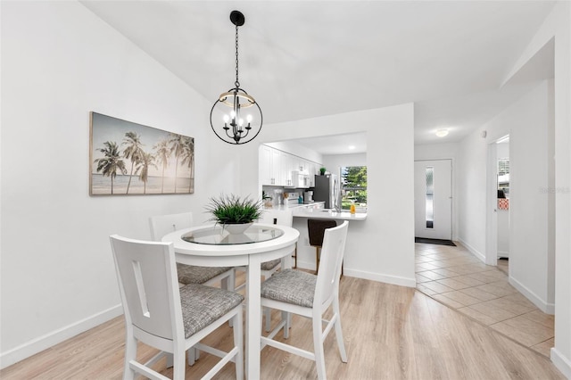 dining area featuring a notable chandelier and light wood-type flooring