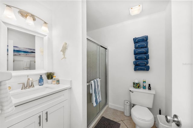 bathroom with walk in shower, vanity, tile patterned flooring, and toilet