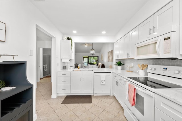 kitchen with white cabinets, decorative light fixtures, sink, and white appliances