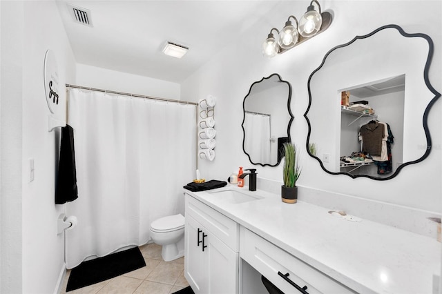 bathroom with walk in shower, vanity, tile patterned flooring, and toilet