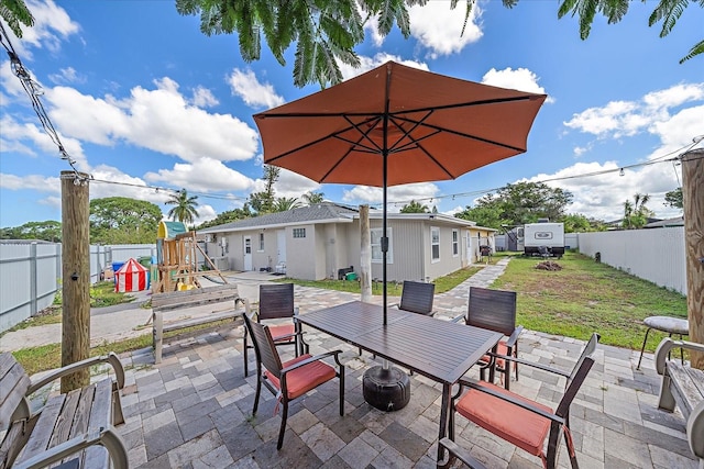 view of patio featuring a playground and a shed