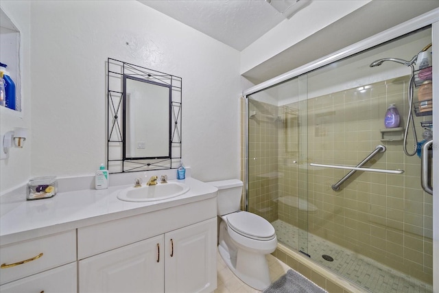 bathroom featuring vanity, tile patterned flooring, toilet, and a shower with door