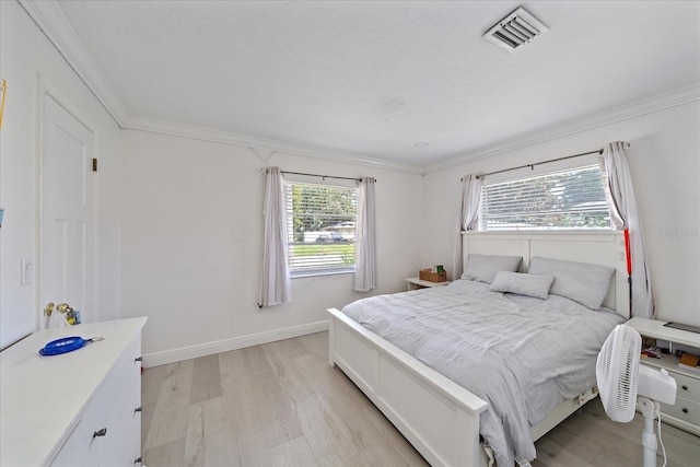 bedroom featuring ornamental molding, light hardwood / wood-style floors, and multiple windows