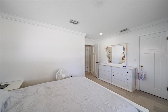 bedroom with light wood-type flooring and crown molding