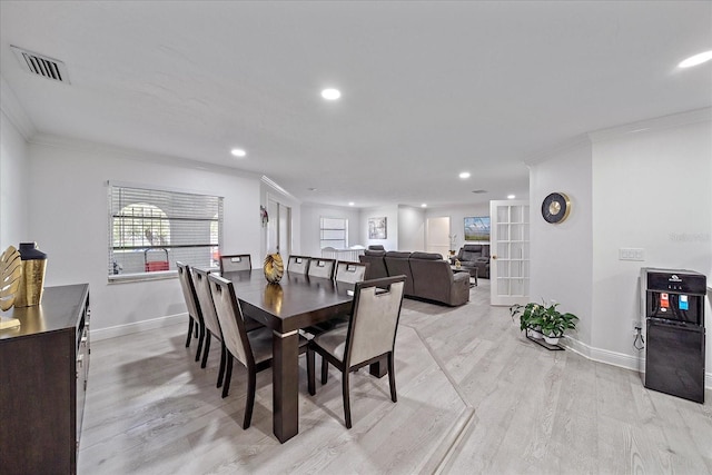 dining area featuring french doors, light wood-type flooring, and ornamental molding