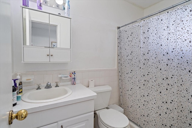 bathroom with vanity, tile walls, toilet, and curtained shower