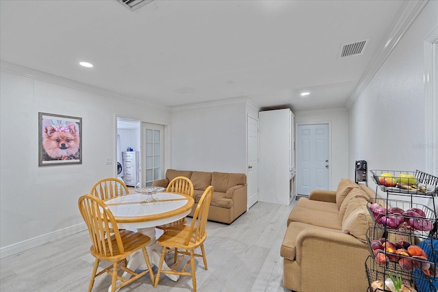 dining area featuring crown molding and light hardwood / wood-style floors