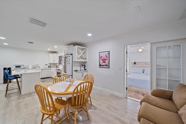 dining room with ceiling fan, light wood-type flooring, and ornamental molding