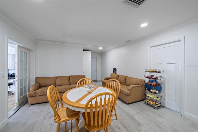 dining room with light hardwood / wood-style flooring and ornamental molding