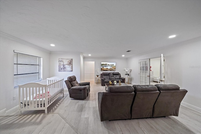 living room with light hardwood / wood-style flooring, ornamental molding, and a healthy amount of sunlight