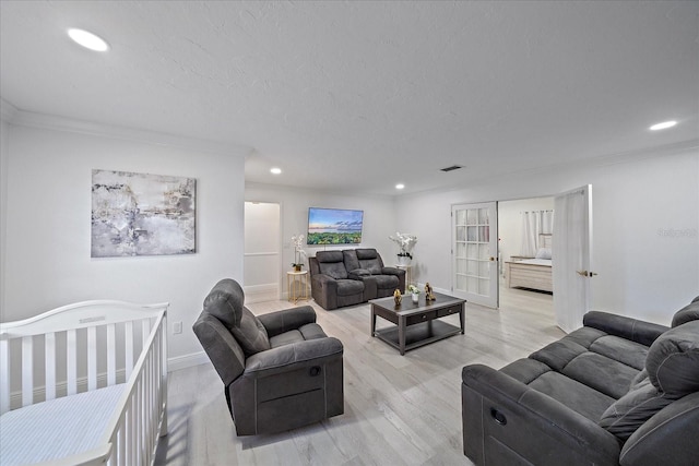 living room featuring light wood-type flooring and crown molding