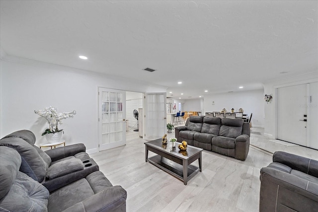 living room with ornamental molding and light hardwood / wood-style floors