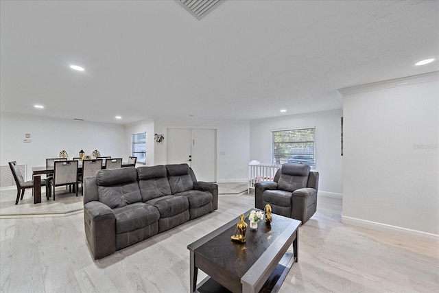 living room featuring light wood-type flooring and crown molding