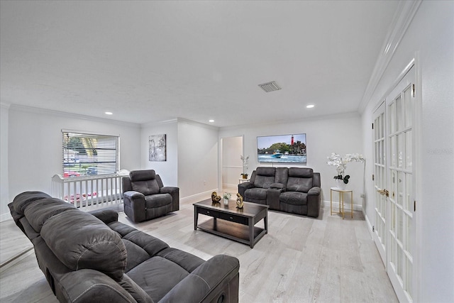 living room with ornamental molding and light hardwood / wood-style flooring