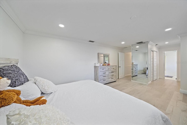 bedroom with ornamental molding and light hardwood / wood-style floors