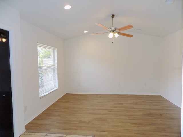 spare room with light hardwood / wood-style flooring, lofted ceiling, and ceiling fan