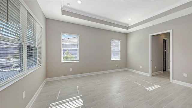 unfurnished room with a raised ceiling and ornamental molding