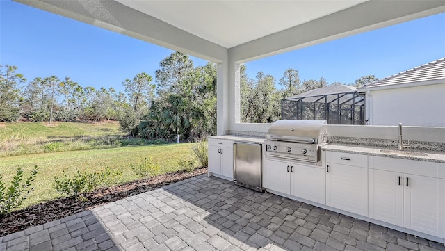 view of patio / terrace featuring a lanai, area for grilling, and sink