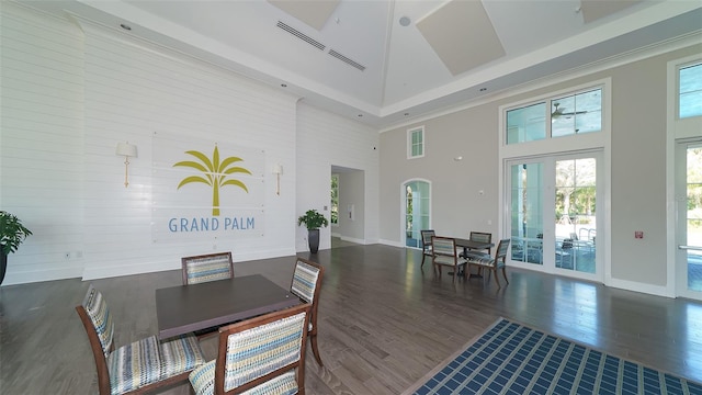 dining area featuring french doors, a towering ceiling, and dark hardwood / wood-style floors