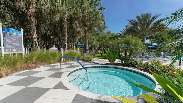 view of swimming pool with a hot tub