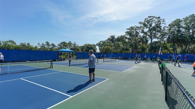 view of tennis court with basketball hoop