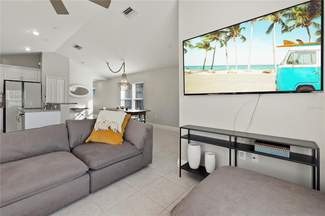 living room with ceiling fan, light tile patterned flooring, and lofted ceiling