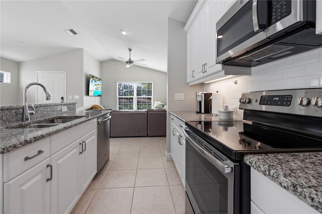 kitchen featuring sink, white cabinets, vaulted ceiling, and appliances with stainless steel finishes