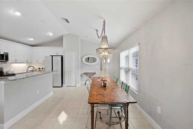 dining area featuring sink, light tile patterned floors, lofted ceiling, and a notable chandelier