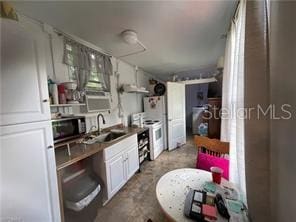 kitchen with white cabinetry, white electric range, and sink