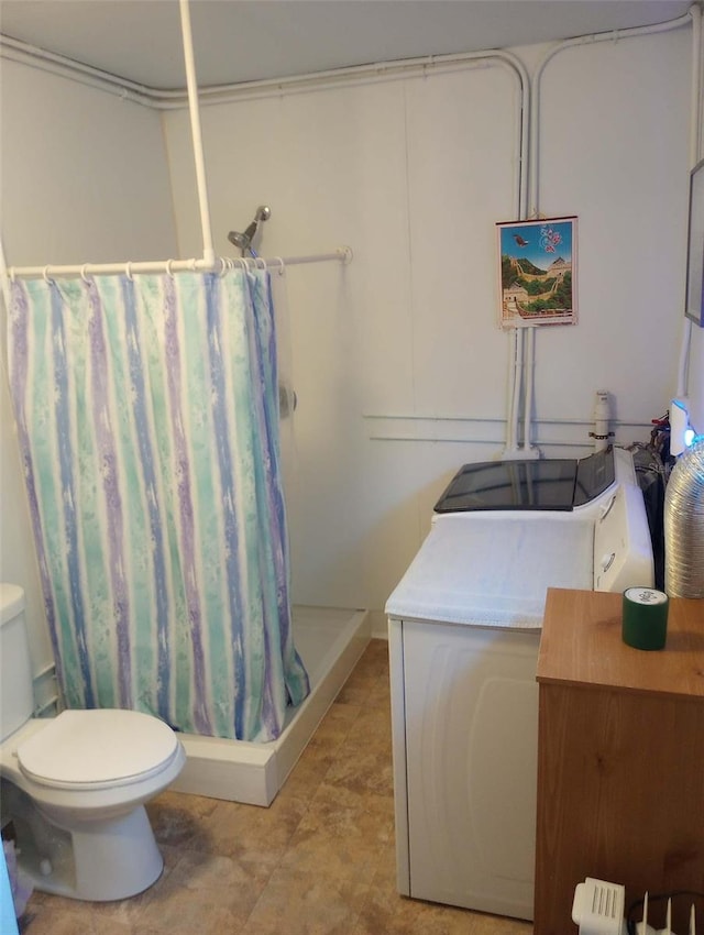 bathroom with washer / dryer, a shower with curtain, vanity, and toilet