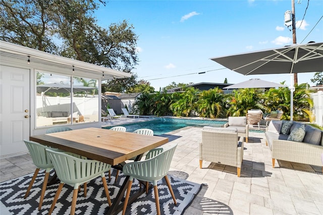 view of pool with an outdoor living space, pool water feature, and a patio