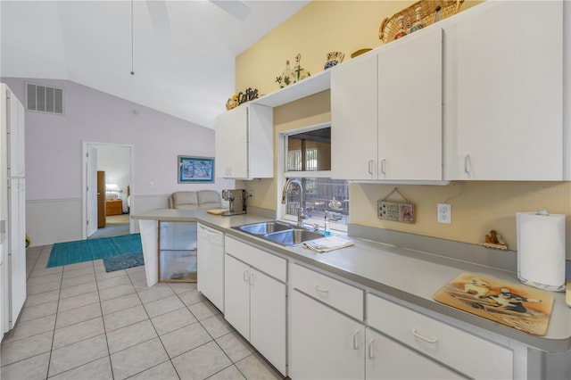 kitchen with lofted ceiling, white cabinetry, light tile patterned floors, and sink