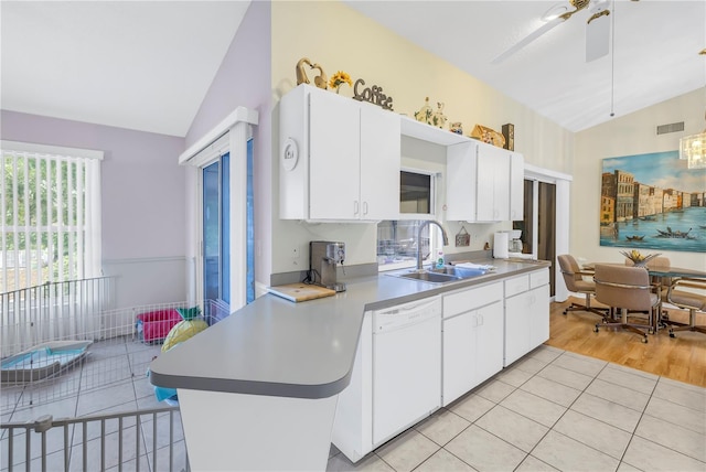 kitchen featuring vaulted ceiling, white cabinetry, and sink