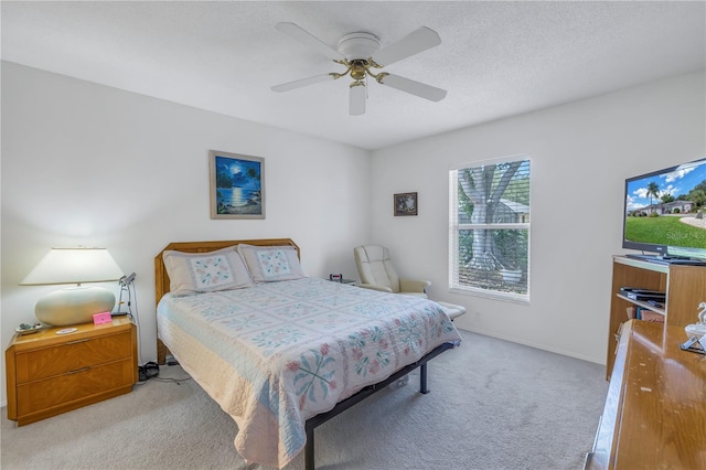 carpeted bedroom featuring a textured ceiling and ceiling fan