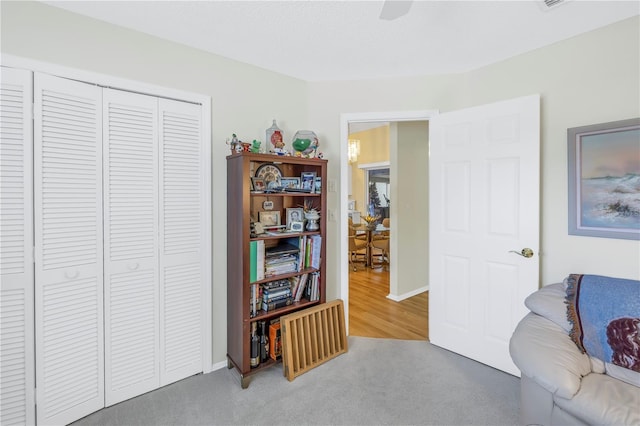 living area with carpet flooring and ceiling fan