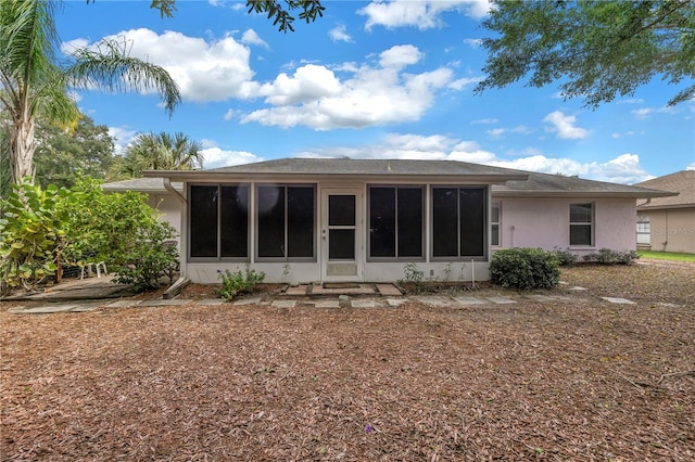 rear view of house featuring a sunroom