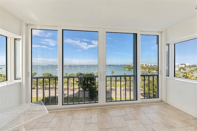 unfurnished sunroom featuring a healthy amount of sunlight and a water view