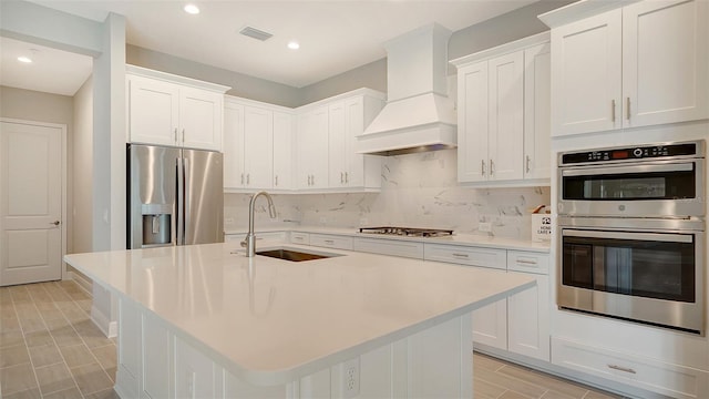 kitchen featuring white cabinets, custom exhaust hood, stainless steel appliances, and sink