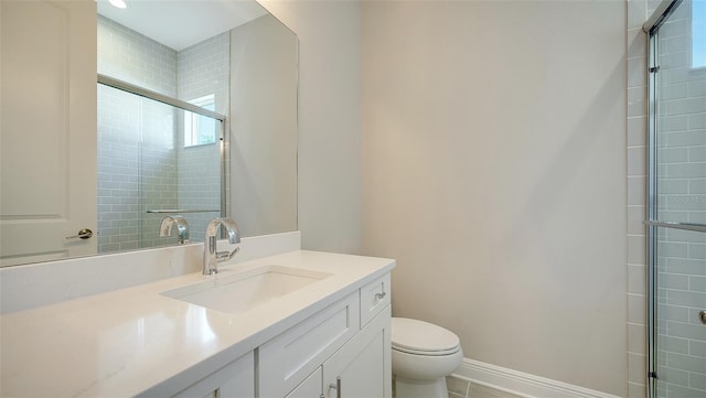 bathroom featuring tile patterned floors, a shower with shower door, vanity, and toilet